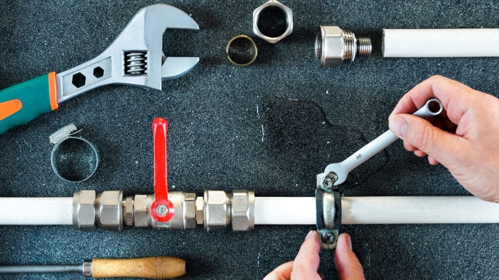 Plumber repairing a pipe valve with an adjustable wrench in Palm Coast