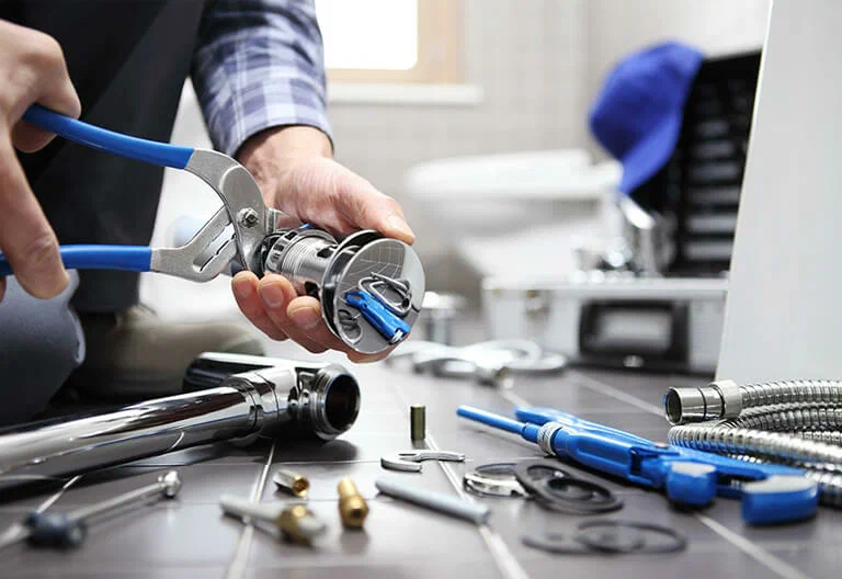Technician repairing a plumbing fixture with professional tools in Palm Coast