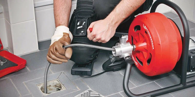 Plumber using a drain-cleaning machine in Palm Coast