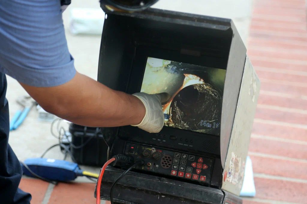 Technician viewing a drain inspection camera in Palm Coast