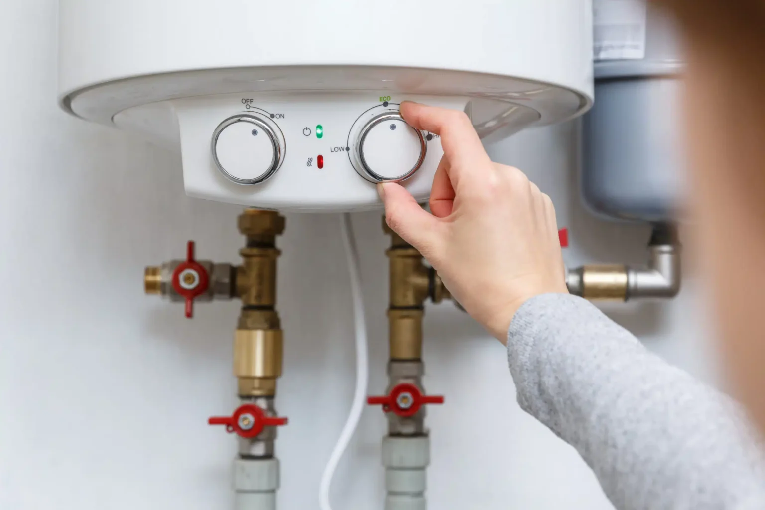 Homeowner adjusting the temperature controls on a water heater in Palm Coast